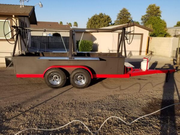 A red and black trailer with a grill on it